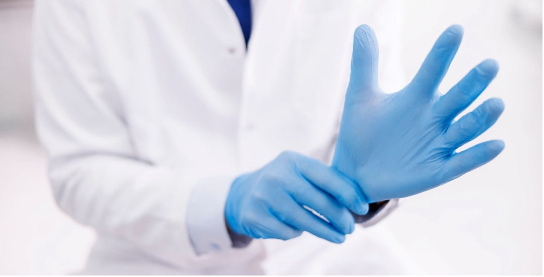 a healthcare or medical professional putting on blue nitrile gloves